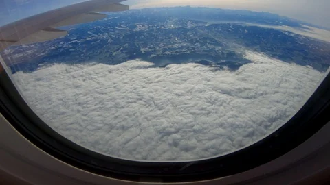 Airplane Window view Flying Above Clouds and Mountain Landscape Stock Footage 103587245
