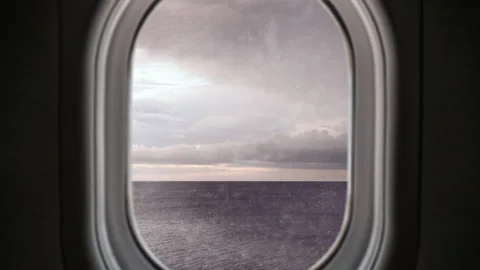 Airplane window view flying over the ocean experiencing turbulence and lightning Video stock 187950757