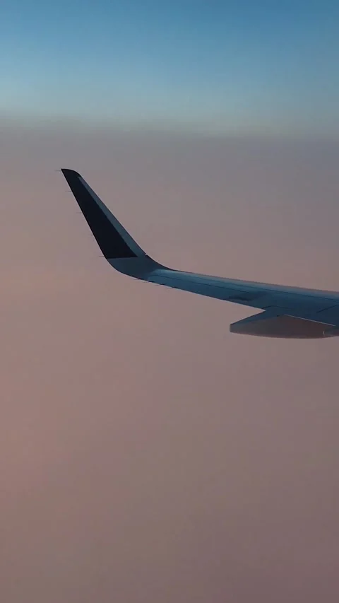 Airplane window view flying at same height as cloud level sunset golden hour Stockbeeldmateriaal 280788988