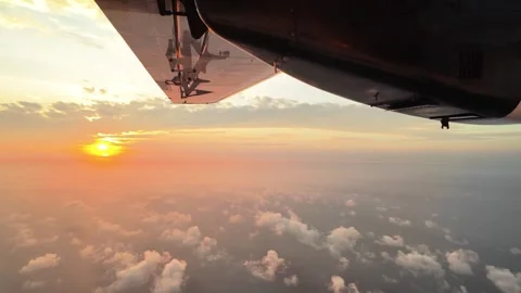 Airplane window view of golden sunset over sea of clouds Stock Footage 335453829