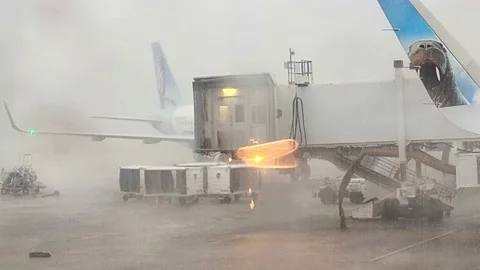 Airplane Window View of Intense Rain at Airport Stock Footage 240021542