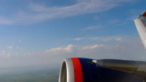 Airplane window view of jet engine and wing over green fields Stock Footage 346664423