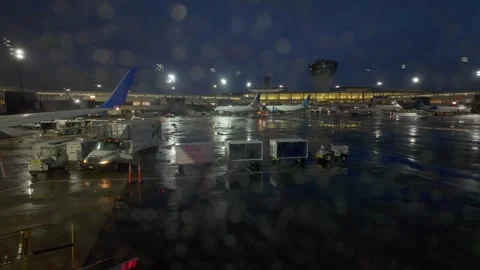 Airplane window view out to Newark airport during rainy night, NJ - 4K Stock Footage 310849361