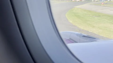 Airplane window view over purple wing panning Stockbeeldmateriaal 333646642