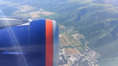Airplane window view showing wing of the plane flying over land. Stock Footage 84803110