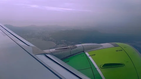 Airplane window view showing wing and turbine flying over land. Passenger plane Stock Footage 123075444