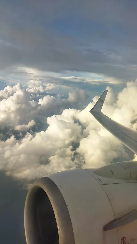 The Airplane Window View Shows a Collection of Beautiful Clouds and The Sea Stock Footage 324568369