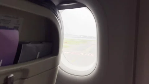 Airplane Window View Before Takeoff with Runway and City Skyline Stock Footage 314916808