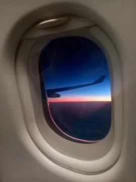 Airplane Window View of Vibrant Sunset Sky and Wing During Flight Stock Photos