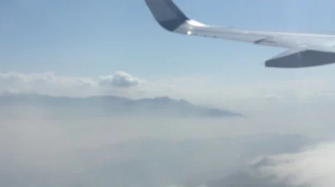 Airplane Window View of Wing , Above Clouds, Flying Stock Footage 48923604