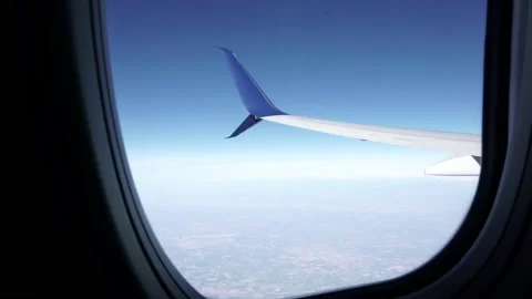 Airplane Window View with Wing and Ground in Focus Stock Footage 146154142