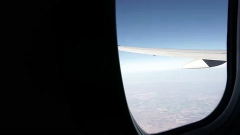 Airplane Window View with Wing and Ground in Focus, Pan Stock Footage 146154156