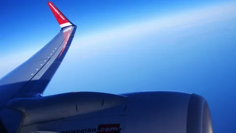 Airplane window view of wing and blue sky Stock Footage 234713799