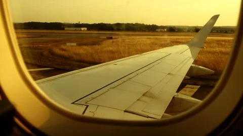 Airplane Window view of wing anf engine landing at airport Stock Photos