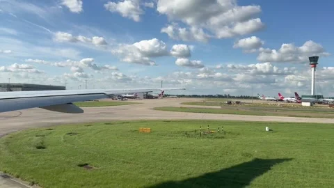 Airplane window view of wing moving across runway at takeoff at Heathrow airport Stock Footage 310331862