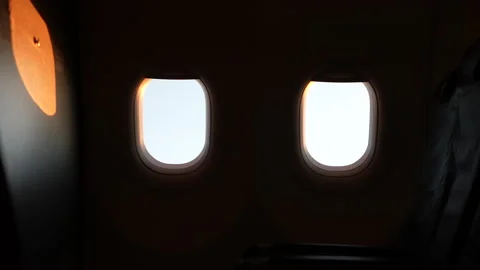 Airplane windows in the sunset over the clouds Stock Footage 220346114
