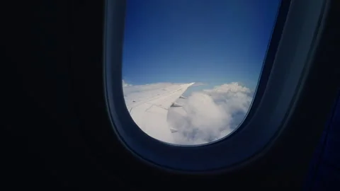 Airplane Wing Above Bright White Clouds Viewed Through Passenger Window During F Stock Footage 337030208