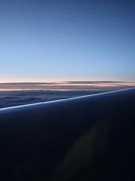 Airplane Wing Above Clouds During Blue Hour Dawn Flight Stock Photos
