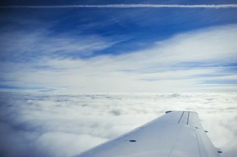 An airplane wing above the clouds Stock Photos