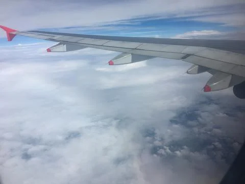 Airplane Wing Above Clouds Seen Through Passenger Window During Flight Travel Stock Photos