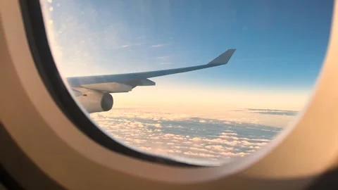 Airplane Wing Above Clouds at Sunset Seen from Window Stock Footage 333693586