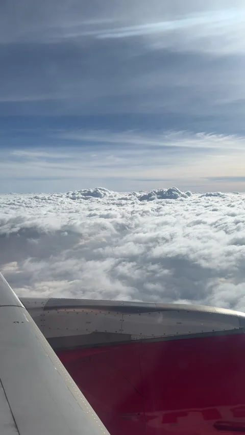 Airplane Wing Above Expansive Cloudscape with Distant Peaks Stock Footage 336484023