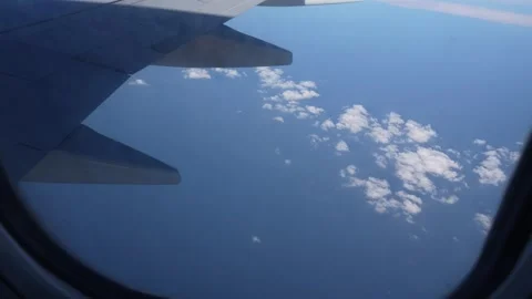 Airplane wing above ocean with clouds visible through window frame Stock-Footage 328916210