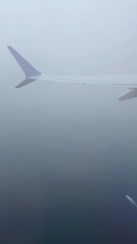Airplane wing above ocean vertical 4k Stock Footage 337137790