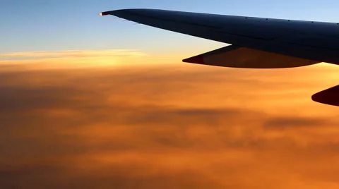 Airplane wing above orange clouds 動画素材 43446420