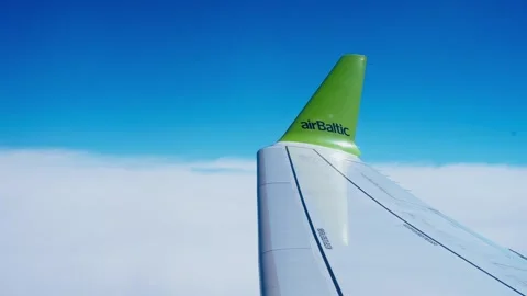 Airplane Wing of airBaltic Flying Over Clouds Against Blue Sky Stock Footage 336709545