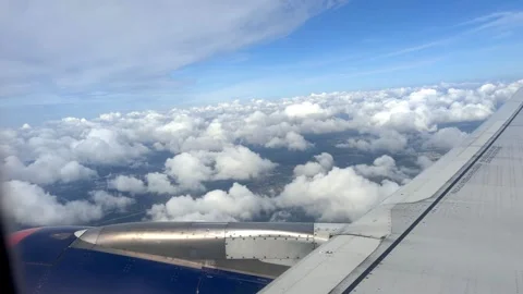 Airplane wing and clouds viewed from window, showcasing the gradual descent Stock Footage 344516203
