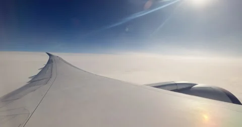 Airplane wing and engine flying above white fluffy clouds,flying with plane Stock Footage 336944457