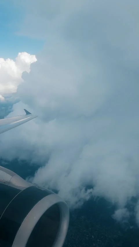 Airplane Wing and Engine Flying Through Thick Cloud Layer with Blue Sky Above. Stock Footage 338360378