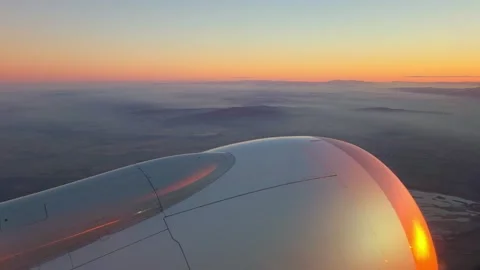 Airplane wing and engine viewed from window during sunset Stock Footage 332679719