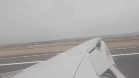 Airplane wing and flaps during landing on runway Stockbeeldmateriaal 345806569