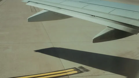 Airplane wing and its shadow on the taxiway close up Video stock 347964867