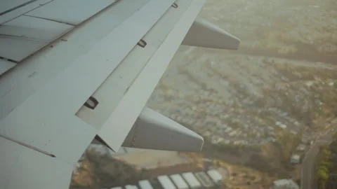 Airplane wing on approach over a freeway and hillside neighborhoods Vídeos de archivo 347983113
