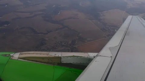Airplane wing. Big Gray wing of an airplane with a green engine attached to it. Stock Footage 117534343