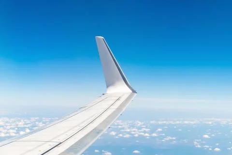 Airplane wing in blue sky with clouds on a clear day Stock Photos