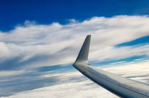 Airplane wing with clouds background and copyspace Stock Photos