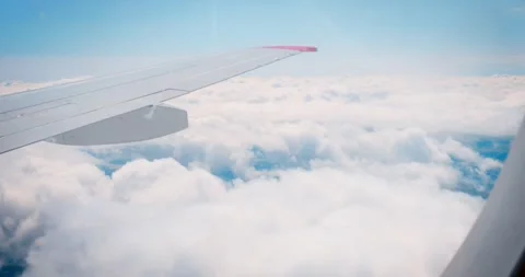 Airplane wing clouds, clear day flight, window view. showcasing aviation Stock Footage 263899622