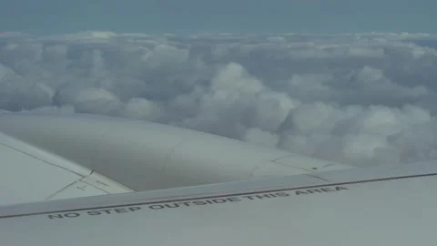 Airplane wing in the clouds with sign on wing, no step outside this area Stock Footage 281012376