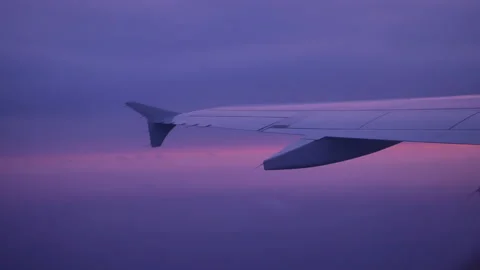 Airplane wing in clouds at sunset - 4K, Handheld, Scenic Stock Footage 193589596