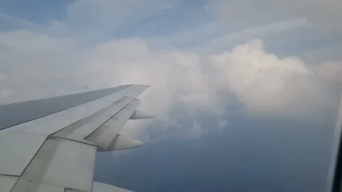 Airplane wing in the clouds. View from the porthole Stock Footage 285620682