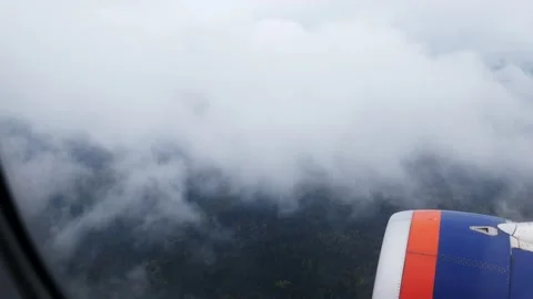 Airplane wing in dense fog. the plane descends and passes the cloud layer. air Stock Footage