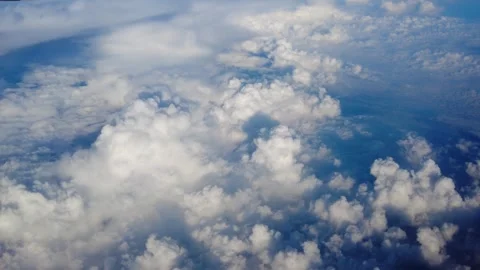 Airplane wing edge slices into frame dense cumulus clouds blanket the view below Stock Footage 343672718