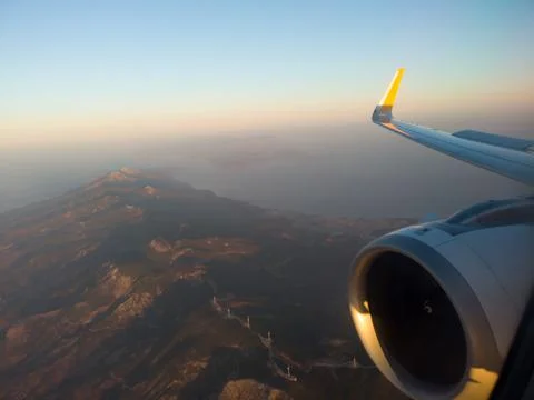 Airplane wing with engine out of window. Flight over land on sunrise. Airplane Stock Photos