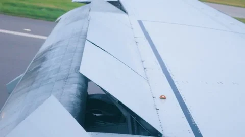 Airplane wing with extended flaps and spoilers during landing braking 스톡 동영상 347240104