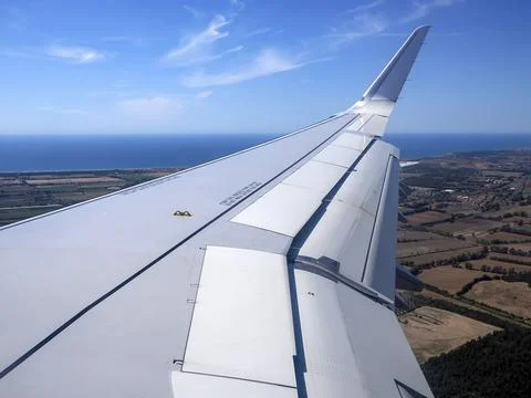 Airplane Wing With Extended Flaps During landing Roll Over Runway At Airport Stock Photos
