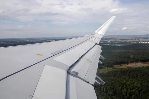 Airplane Wing With Extended Flaps During landing Roll Over Runway At Airport Stock Photos